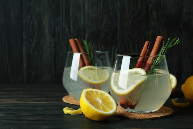 Vasos de limonada en la superficie de madera, espacio para texto