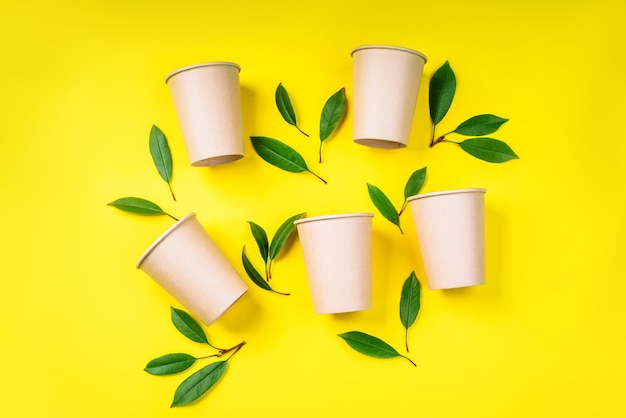 Vasos de papel reciclado Concepto de cero residuosVasos de papel desechables sobre un fondo amarillo