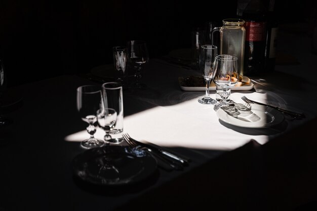 Vasos, plato y cubiertos sobre la mesa. Ajuste de la mesa en el restaurante.