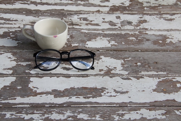 Vasos y taza blanca en la mesa de madera vieja