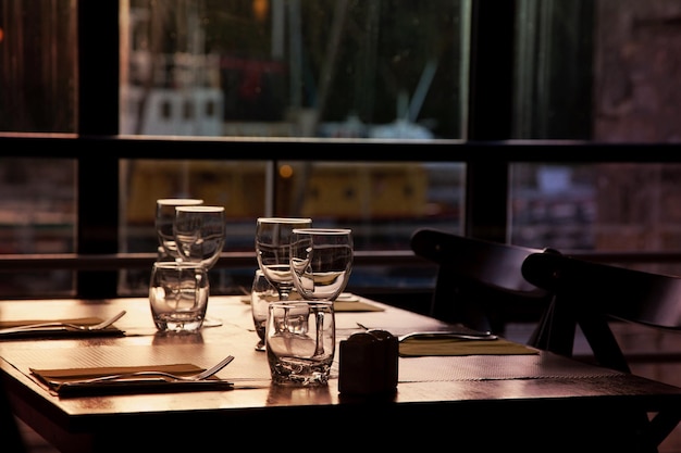 Vasos y tenedores en la mesa junto a la ventana.
