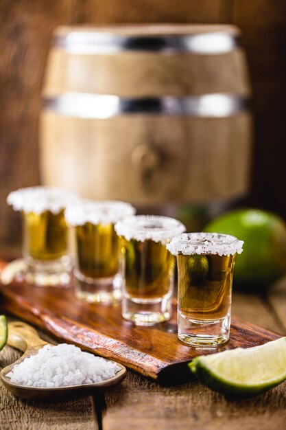 Vasos de tequila en la mesa de la barra, servidos con sal y limón.