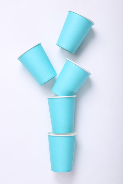 Foto vasos vacíos de cartón azul sobre un fondo blanco.