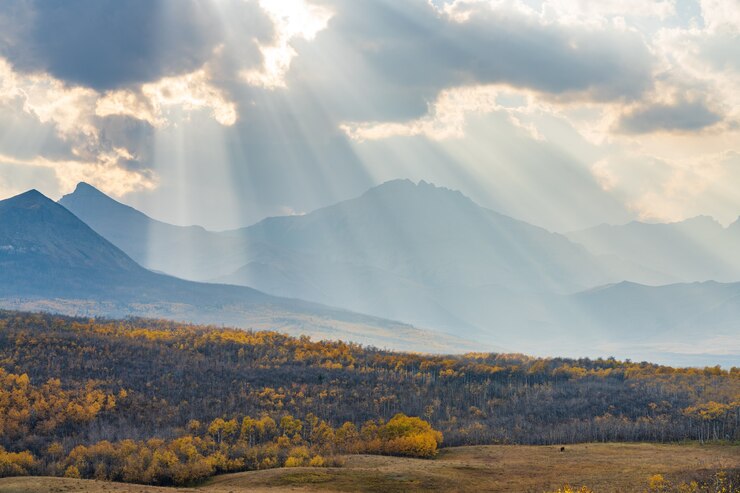 Vastas praderas y bosques en un hermoso otoño. La luz del sol pasa por el cielo azul y las nubes en las montañas. Waterton Scenic Spot, Parque Nacional Waterton Lakes, Alberta, Canadá.