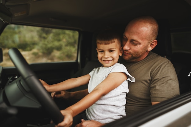 Vater bringt kleinem Sohn das Autofahren auf Roadtrip bei