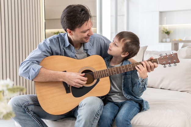 Vater bringt seinem Sohn das Gitarrespielen bei