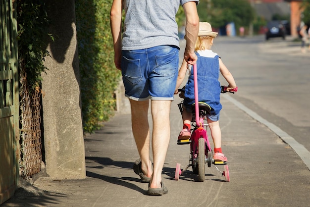 Vater bringt seiner Tochter das Fahrradfahren bei