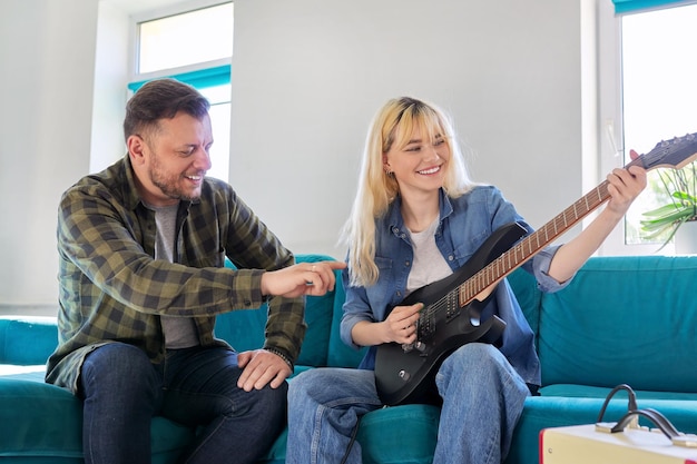 Vater bringt seiner Tochter im Teenageralter bei, E-Gitarre zu spielen