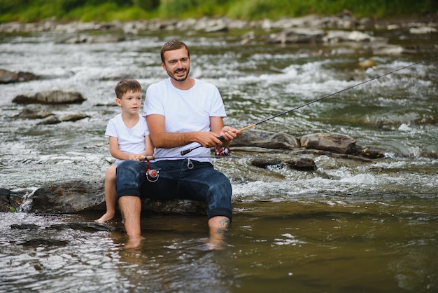 Vater bringt Sohn bei, wie man im Fluss fischt