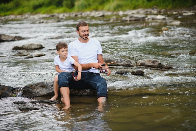 Vater bringt Sohn bei, wie man im Fluss fischt