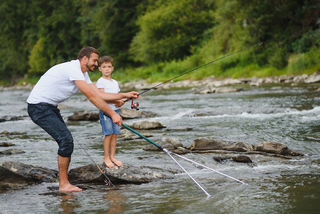 Vater bringt Sohn bei, wie man im Fluss fischt