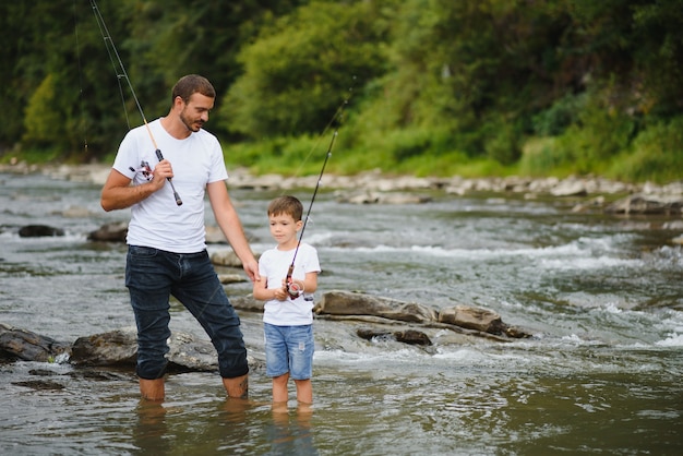 Foto vater bringt sohn bei, wie man im fluss fischt