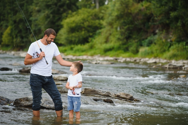 Vater bringt Sohn bei, wie man im Fluss fischt