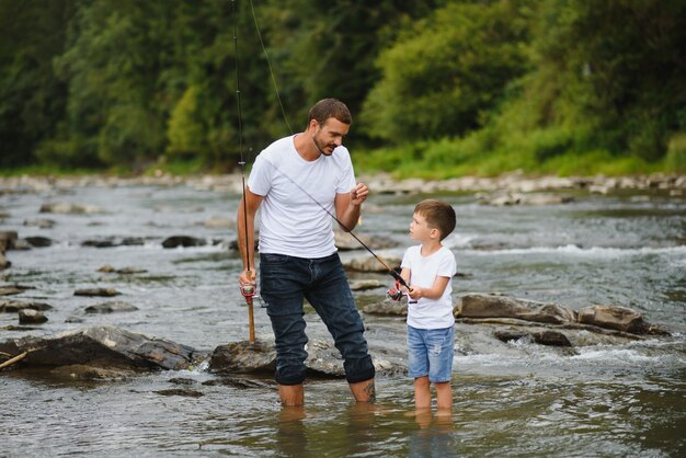 Foto vater bringt sohn bei, wie man im fluss fischt