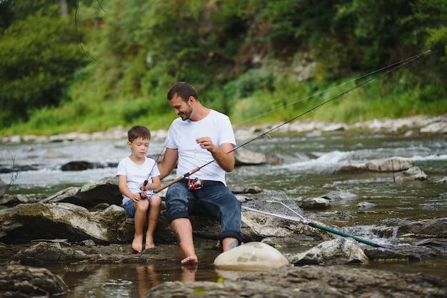 Vater bringt Sohn bei, wie man im Fluss fischt