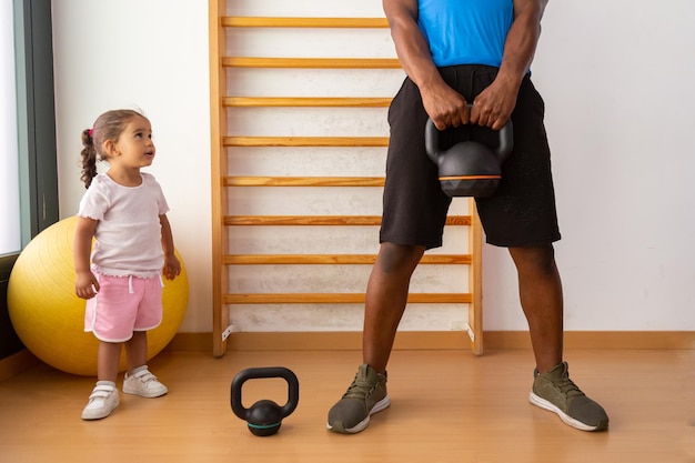 Vater, der mit seiner Tochter Kettlebell hebt