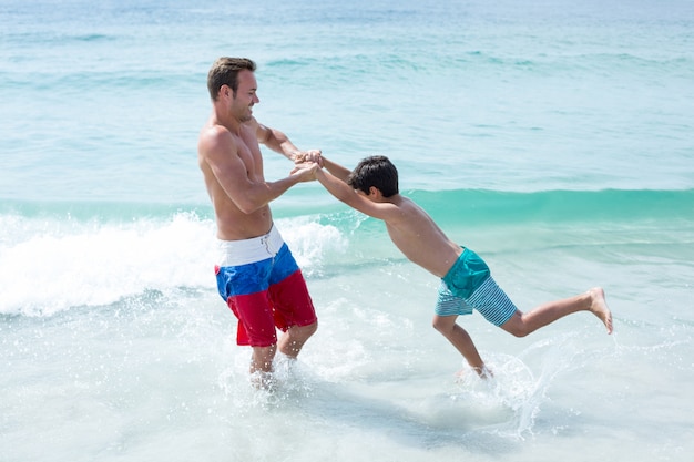 Vater, der mit Sohn am Strand spielt