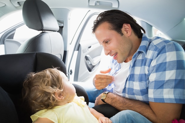 Vater, der sein Baby im Autositz sichert