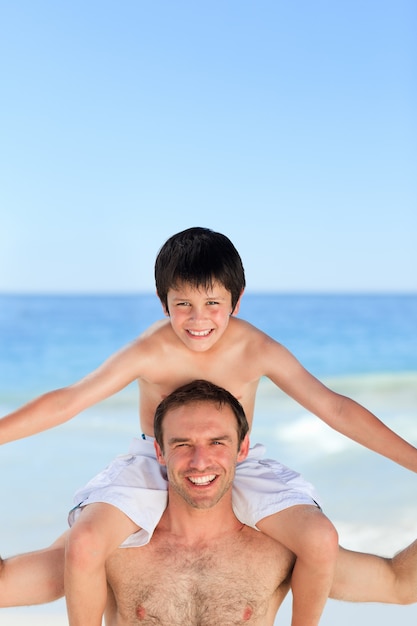 Vater, der Sohn ein Doppelpol auf dem Strand hat