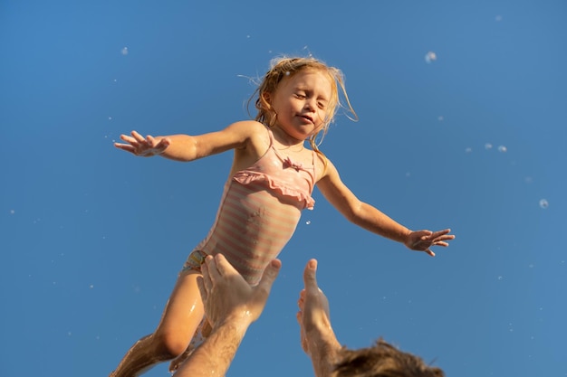 Vater, der zwei Jahre altes kaukasisches blondes Mädchen spieltVater und TochterKind verbringt Zeit zusammen im SchwimmbadGlückliche Kindheit Familienkonzept