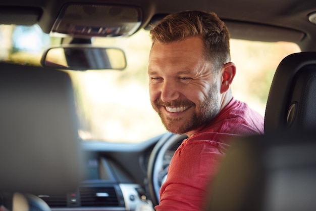 Vater dreht sich um, um mit Kindern auf dem Rücksitz auf der Autofahrt zu sprechen