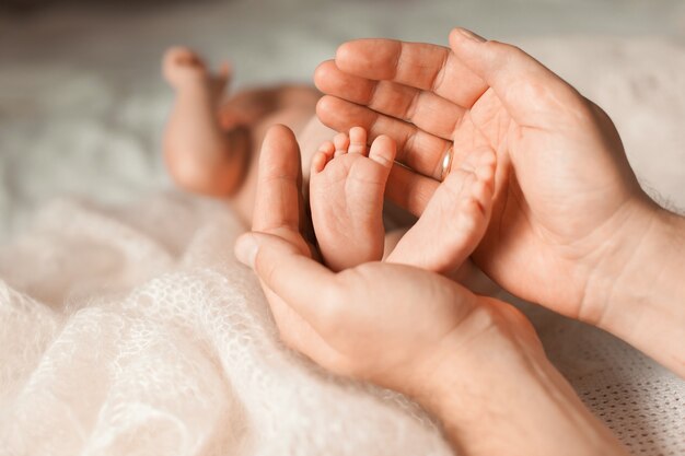 Foto vater hält die füße des neugeborenen in seinen handflächen