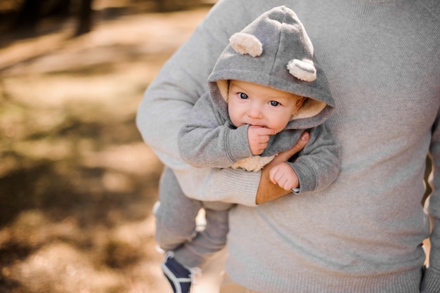 Vater hält einen süßen kleinen Sohn unter dem Arm