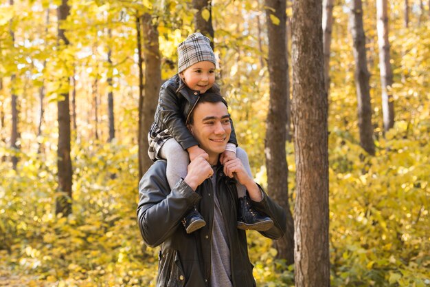 Vater hält seine Tochter im Herbstpark