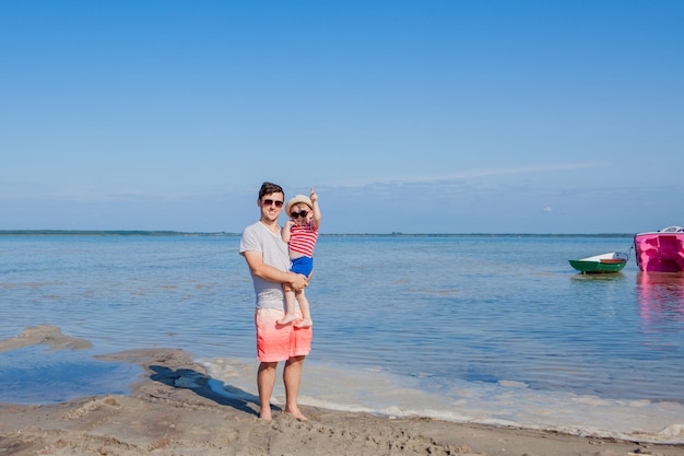 Vater hält Sohn auf seinen Händen am Strand