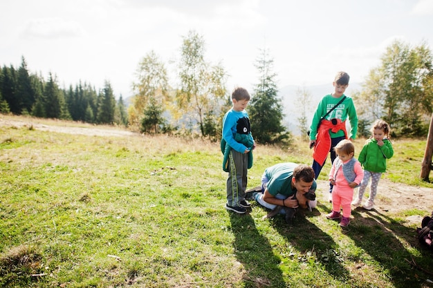 Vater halten Kitty mit vier Kindern in den Bergen Familie liebt die Natur