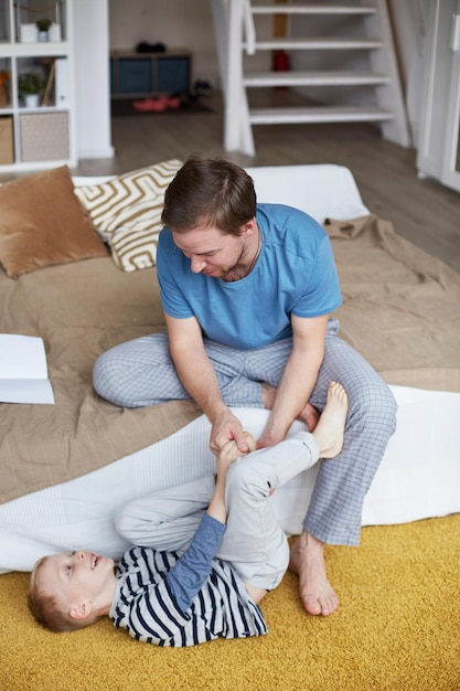 Vater kitzelt den Fuß seines Sohnes