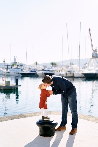 Vater küsst seine Tochter auf einem Bootsanleger in Montenegro.