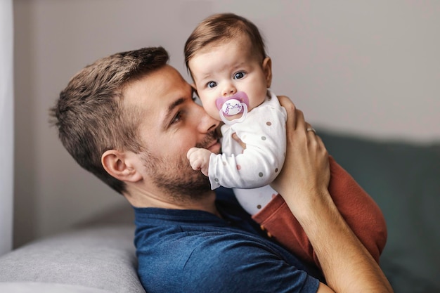 Vater kuschelt zu Hause mit einem kleinen Mädchen