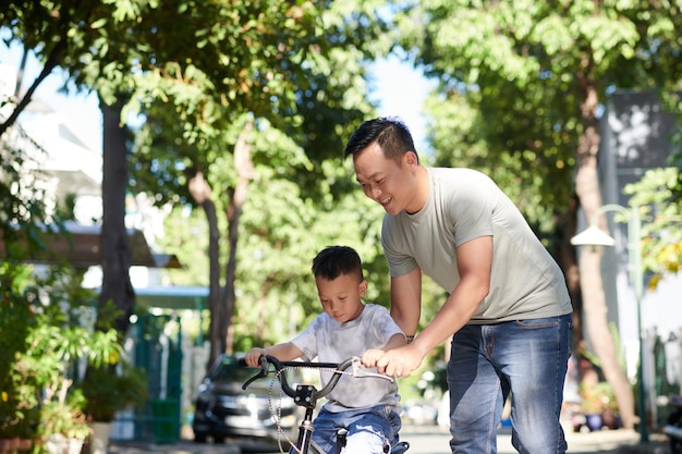 Vater lehrt Kind Radfahren