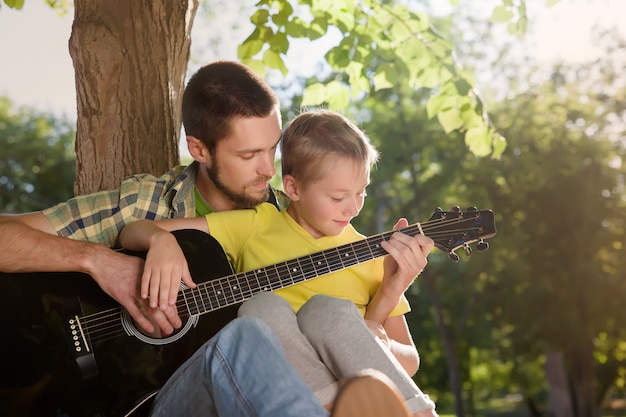 Vater lernt seinen Jungen Gitarre zu spielen