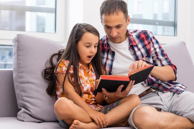 Vater liest seiner kleinen Tochter zu Hause die Bibel vor