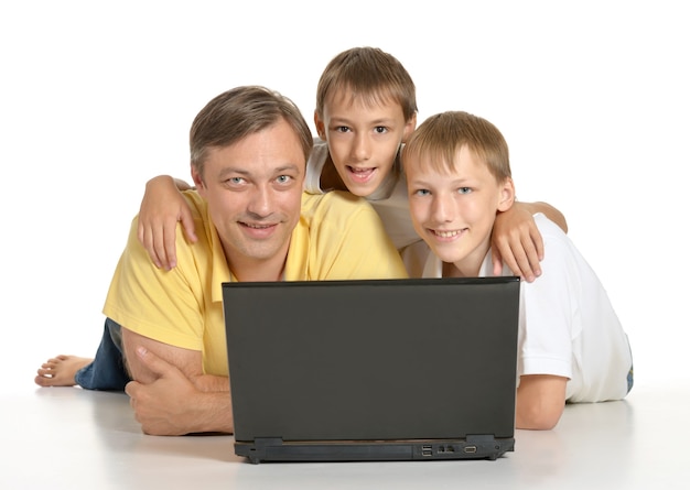 Vater mit Jungen mit Laptop auf dem Boden