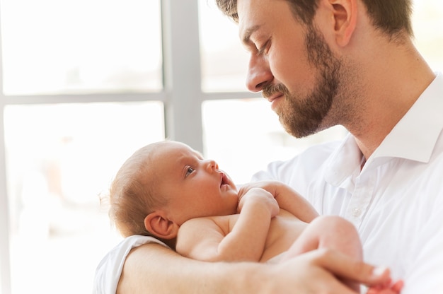 Vater mit kleinem Baby. Nahaufnahme des Vaters, der süßes kleines Baby in den Händen hält