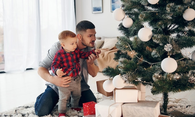 Vater mit seinem kleinen Sohn feiert Neujahr und Weihnachten zusammen