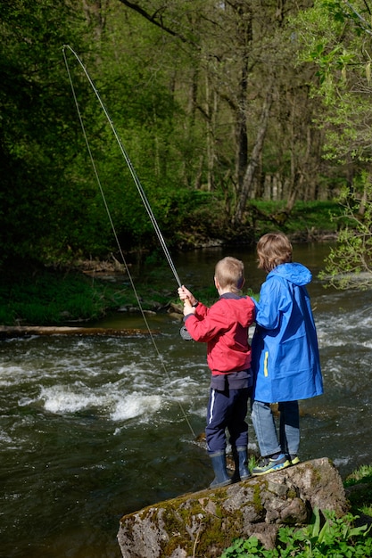 Vater mit seinen Söhnen, die auf dem Berg fischen