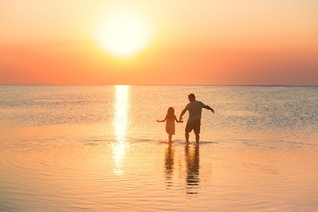 Vater mit Tochter zu Fuß am Meer