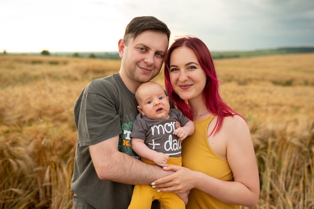 Vater, Mutter und ihr kleiner Sohn haben gemeinsam Spaß auf einem Weizenfeld