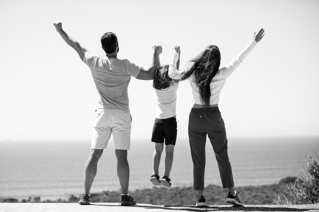 Vater, Mutter und Kind am Sommerstrand bei Sonnenuntergang freundliche Familie Familienreise Urlaub