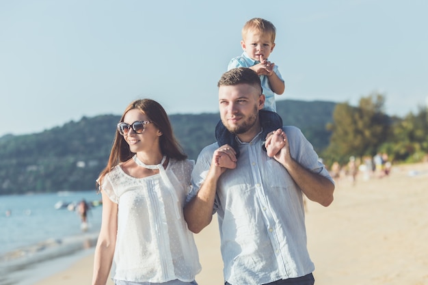 Vater, Mutter und Kind mit Relax-Aktivität, Wandern und Spielen am tropischen Strand