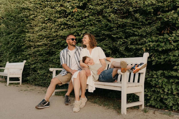 Vater, Mutter und Sohn sitzen auf den Stufen im Garten einer Altstadt