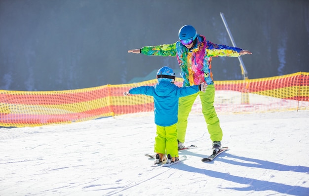 Foto vater oder ausbilder bringen dem kleinen jungen das skifahren bei