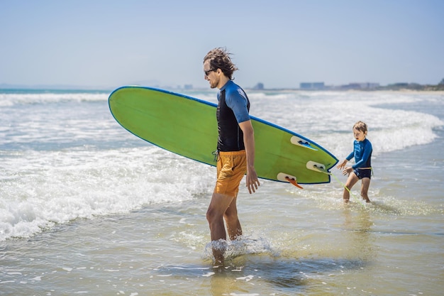 Vater oder Lehrer, der seinem Sohn beibringt, wie man im Urlaub oder auf Urlaubsreisen im Meer surft und