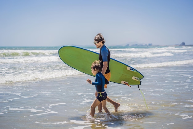 Vater oder Lehrer, der seinem Sohn beibringt, wie man im Urlaub oder auf Urlaubsreisen im Meer surft und