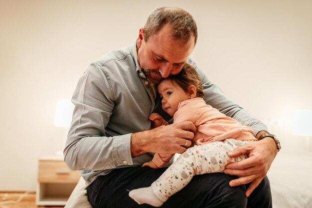 Vater sitzt mit einem kleinen Mädchen