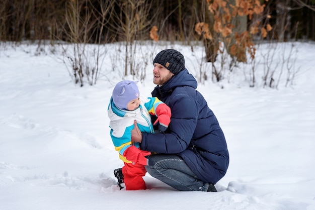 Vater spielt mit seinem Kind draußen im Schnee